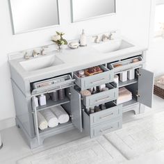 two sinks and mirrors in a bathroom with towels on the counter top, one is gray