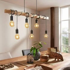 a dining room table with some lights hanging from it's ceiling and an elephant figurine on the table