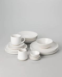 white dishes and cups are stacked on top of each other