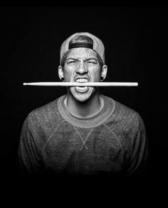 a black and white photo of a man with a stick in his mouth