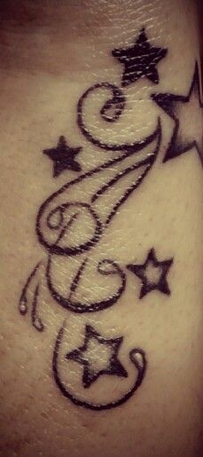 a tattoo on the side of a woman's stomach with stars and swirls