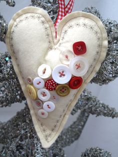 a heart shaped ornament with buttons attached to it