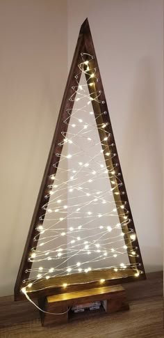 a lighted christmas tree on a wooden stand