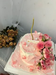 there is a pink cake with flowers on it