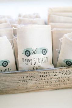 birthday bags with cars on them are sitting in a crate, ready to be used as favors