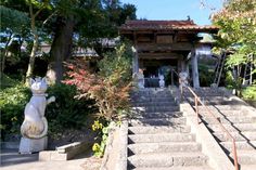 a stone cat statue sitting in front of a building with steps leading up to it