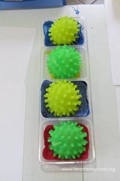 four different colored balls in a plastic container