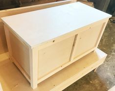 a white cabinet sitting on top of a hard wood floor next to a piece of plywood