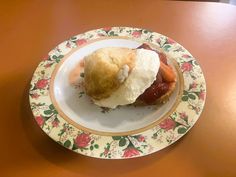 a plate with a pastry on top of it sitting on a table next to a cup