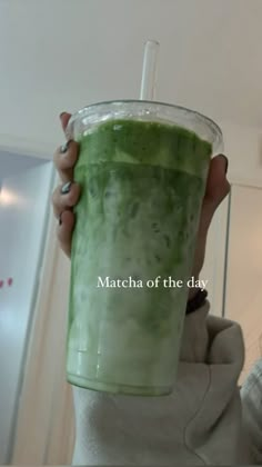 a woman holding up a green smoothie in front of her face with the caption matcha of the day