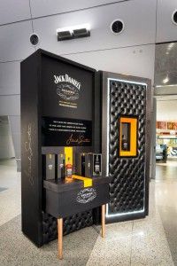 a display case in the middle of an airport with bottles on it and writing on the side