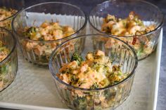 several glass bowls filled with food on top of a white tray next to each other