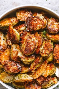 a white bowl filled with brussel sprouts and topped with parmesan cheese