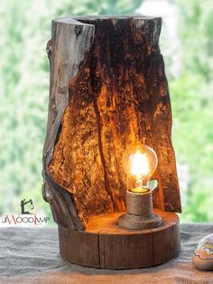 a light that is on top of a wooden stand next to some rocks and trees