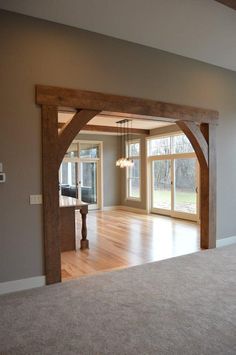 an empty living room with wooden beams and windows