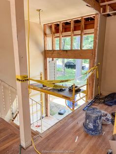 the inside of a house being remodeled with construction tape on the floor and yellow safety ropes