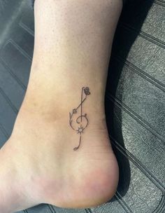 a small flower tattoo on the ankle