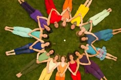 a group of people standing in the middle of a circle on top of green grass