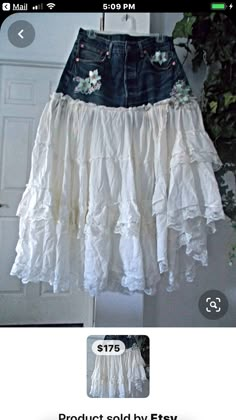 a white skirt with flowers on it is hanging from a door frame and has the price tag