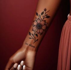 a woman's arm with a sunflower tattoo on the left side of her arm