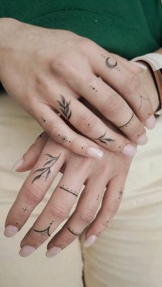 two hands with tattoos on them holding each other's fingers and the other hand