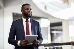 a man in a suit and tie holding a tablet