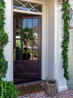 the front door is decorated with greenery and wreaths