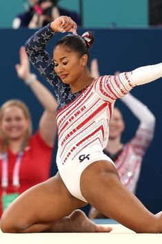 a woman is doing an acrobatic move on the floor