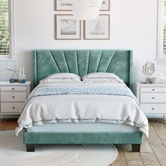 a bed with blue velvet headboard and white linens in a bright bedroom setting