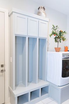 a white laundry room with built in cabinets