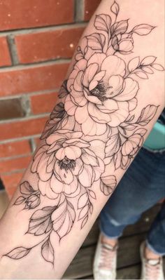 a black and white flower tattoo on the arm