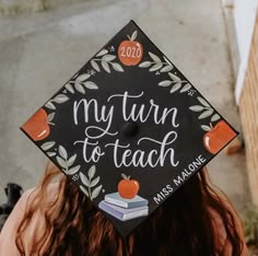 a woman wearing a graduation cap that reads, my turn to teach