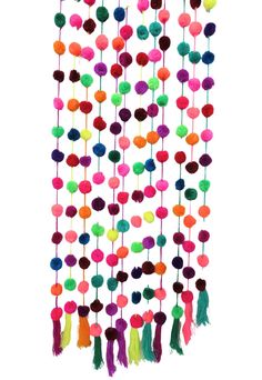 a multicolored wall hanging with pom poms