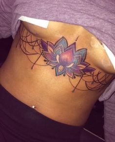 a woman's stomach with a tattoo on her lower back and the bottom part of her abdomen