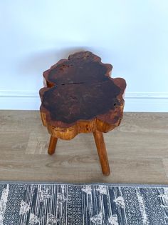 a wooden table sitting on top of a hard wood floor next to a white wall