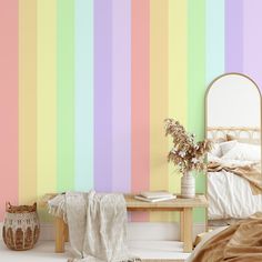 a bedroom with a bed, mirror and rainbow striped wallpaper