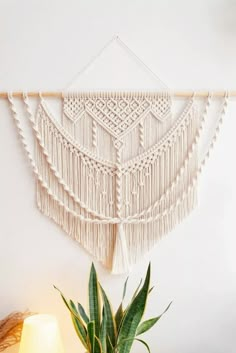 a plant sitting on top of a table next to a wall hanging