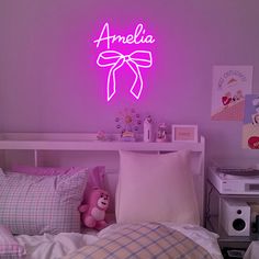 a bed room with a neatly made bed and a neon sign on the wall above it