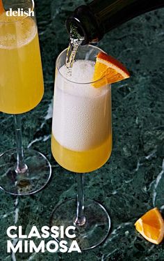 two glasses filled with drinks sitting next to each other on top of a marble counter