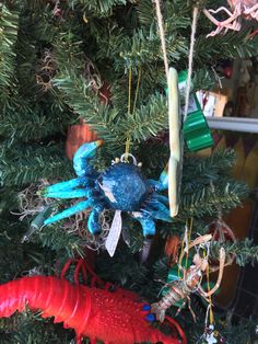 an ornament hanging from the top of a christmas tree with red and blue ornaments