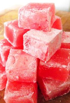 a pile of watermelon cubes sitting on top of a wooden cutting board