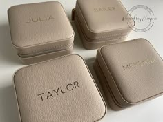 four pieces of luggage sitting on top of a white table with the name taylor written on it