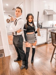 a man and woman dressed up in costume standing next to each other on a wooden floor