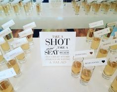 there are many shot glasses on the table with name tags attached to them and place cards in front of them