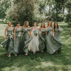 a group of women standing next to each other on top of a lush green field