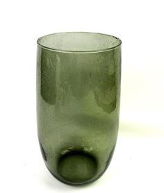 a green glass cup sitting on top of a white table