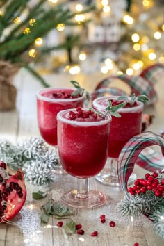 two glasses filled with pomegranate on top of a table