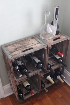 two wooden crates filled with wine bottles on top of a hard wood floor next to a wall