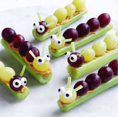 caterpillars and grapes are arranged on cucumber slices to look like fruit