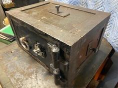 an old metal box sitting on top of a table